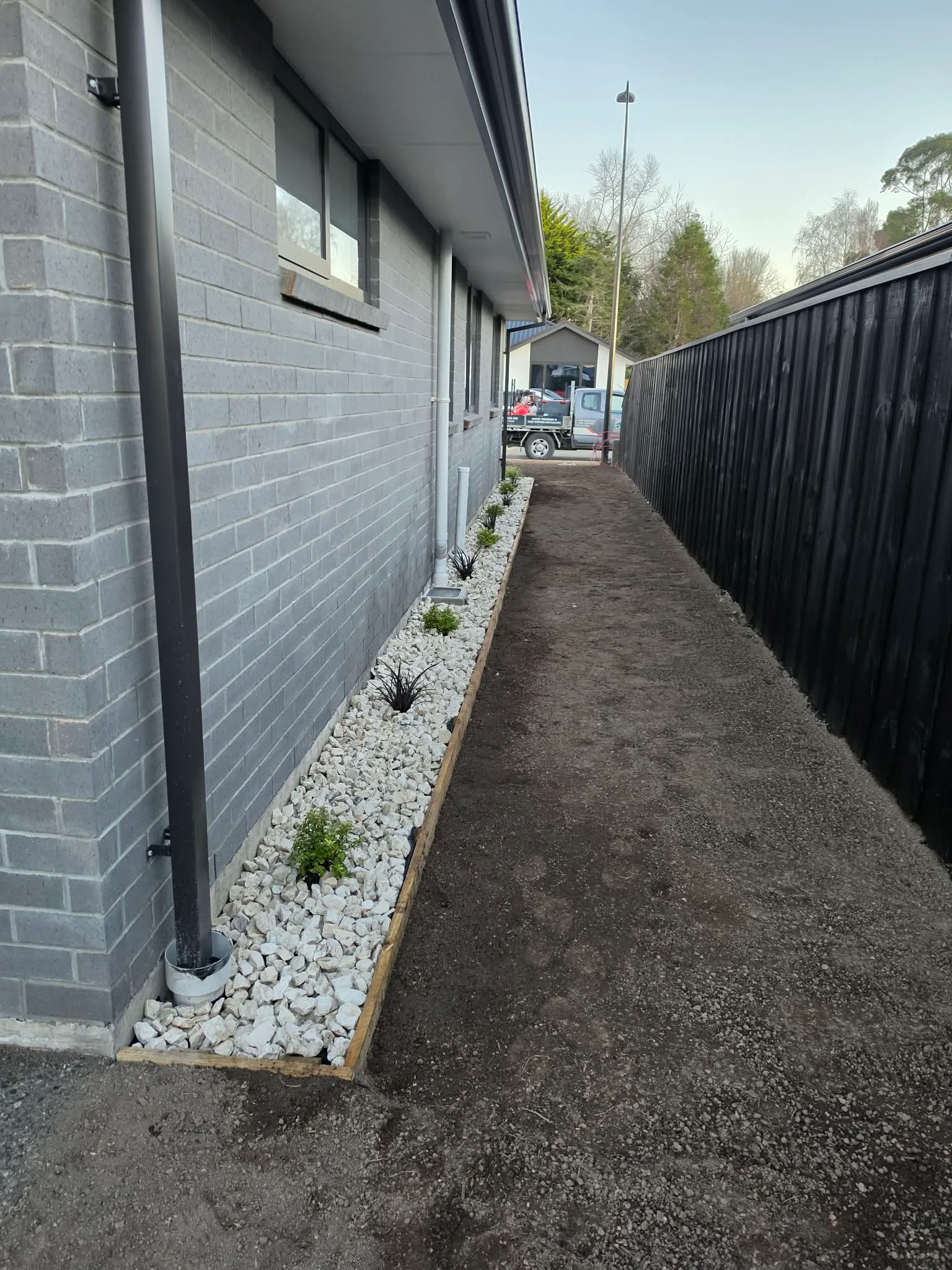 Gravel garden bed with ornamental planting along the side of the home at 25 Derbridge Street