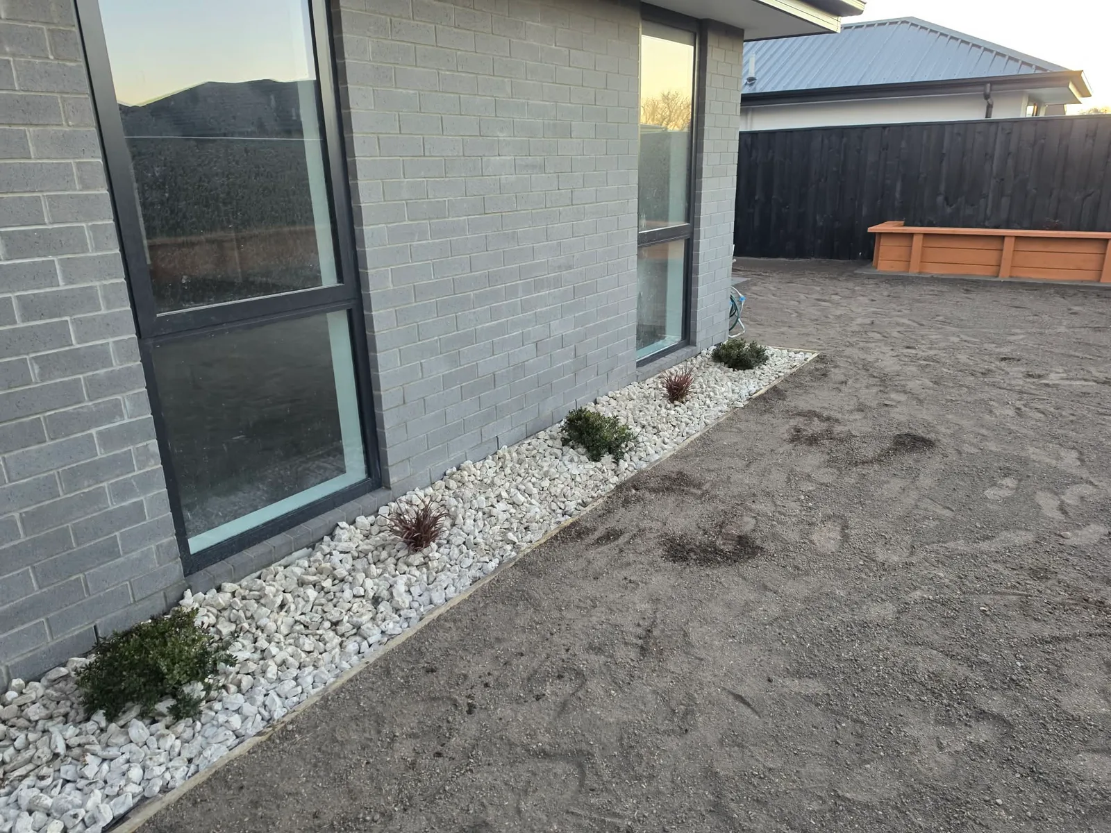 Garden bed with ornamental planting and decorative stone at 25 Derbridge Street, Christchurch