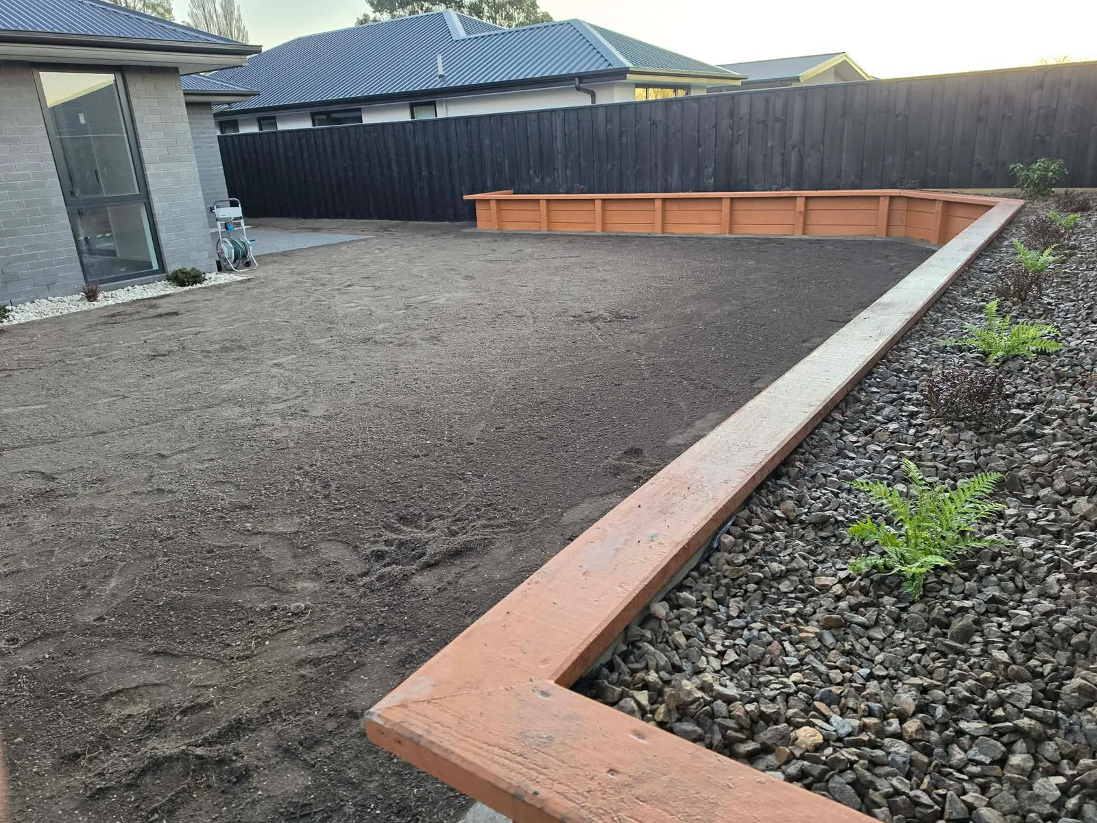 Rear yard with raised timber planter beds and lawn preparation at 25 Derbridge Street, Christchurch